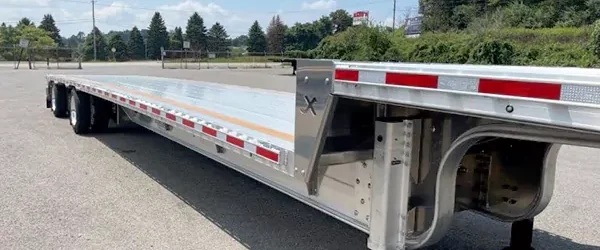 Step deck flatbed trailer designed for transporting taller cargo.